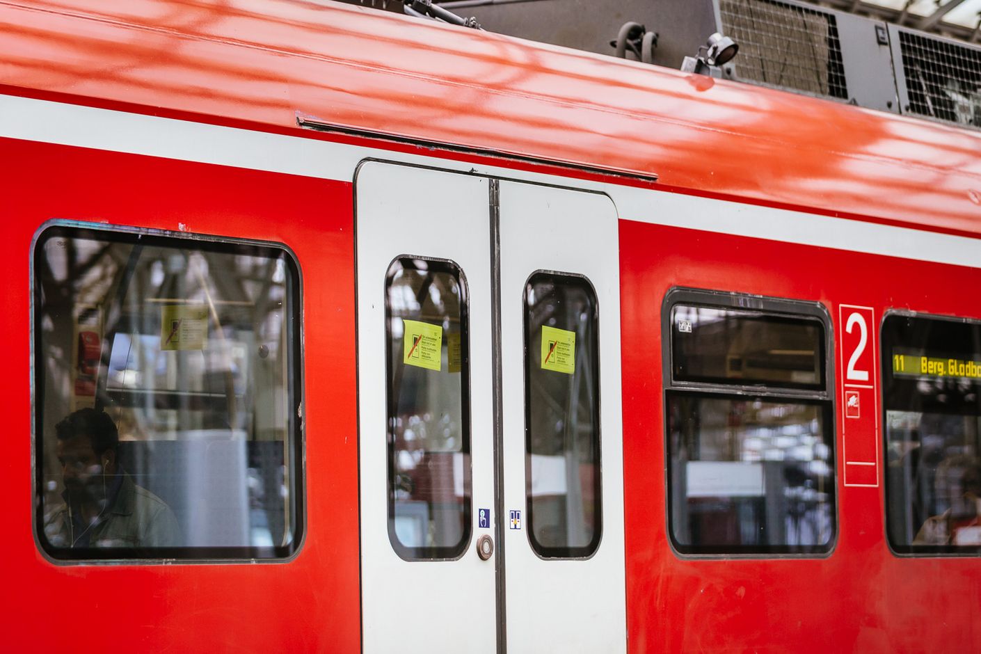 An einer S-Bahn-Tür klebt der typische gelbe Aufkleber, der auf eine Fehlfunktion hinweist und die Fahrgäste bittet, eine andere Tür zu nehmen.